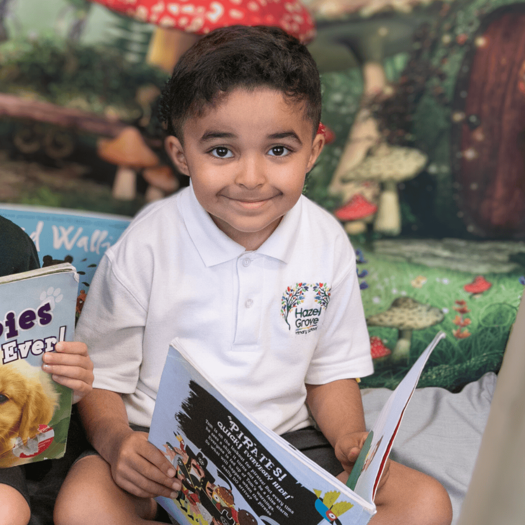 A boy wears the Hazel Grove Pre-School uniform of white polo with school logo.